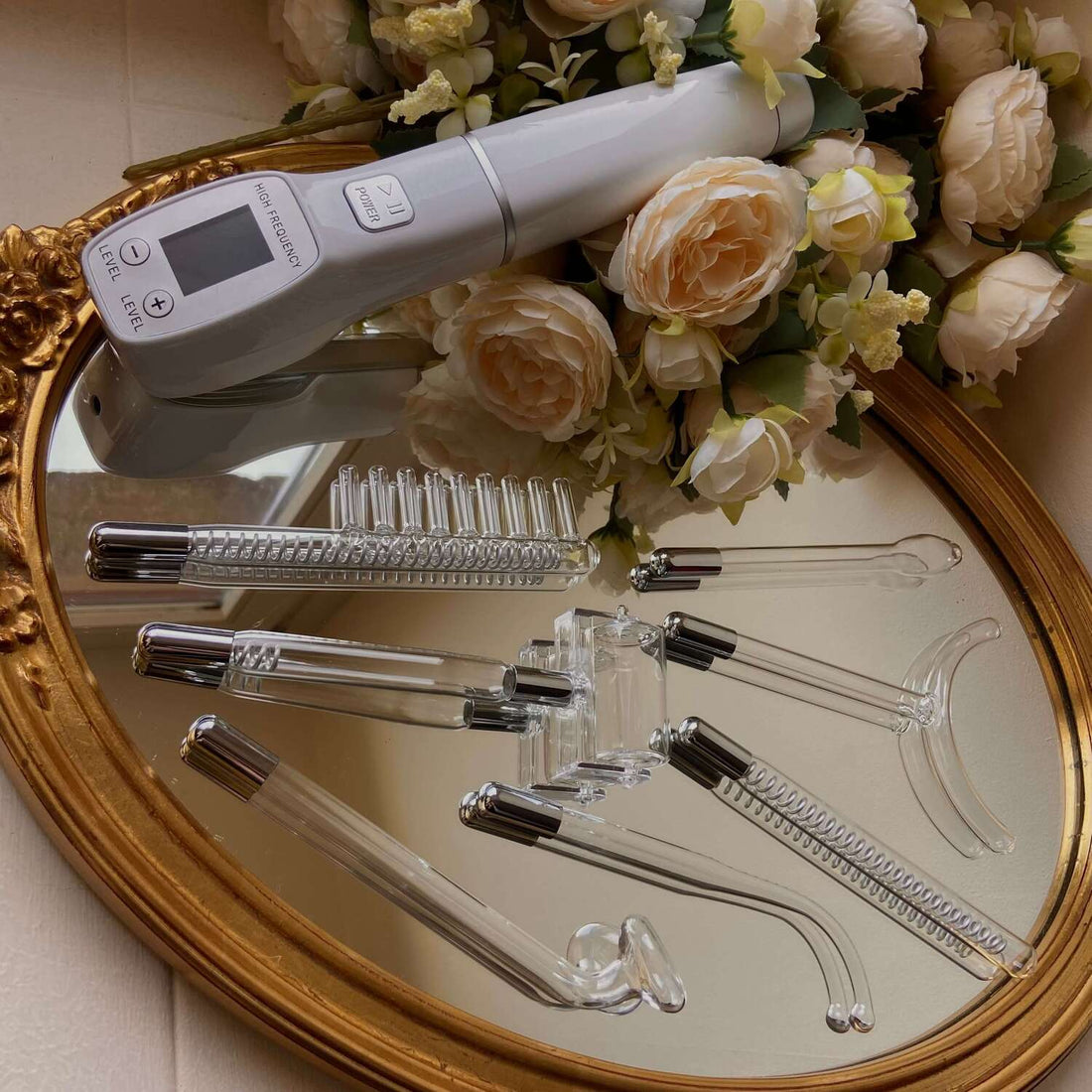 Appareil de haute fréquence avec ses électrodes en verre posés sur un plateau miroir, soin du visage pour purifier et revitaliser la peau